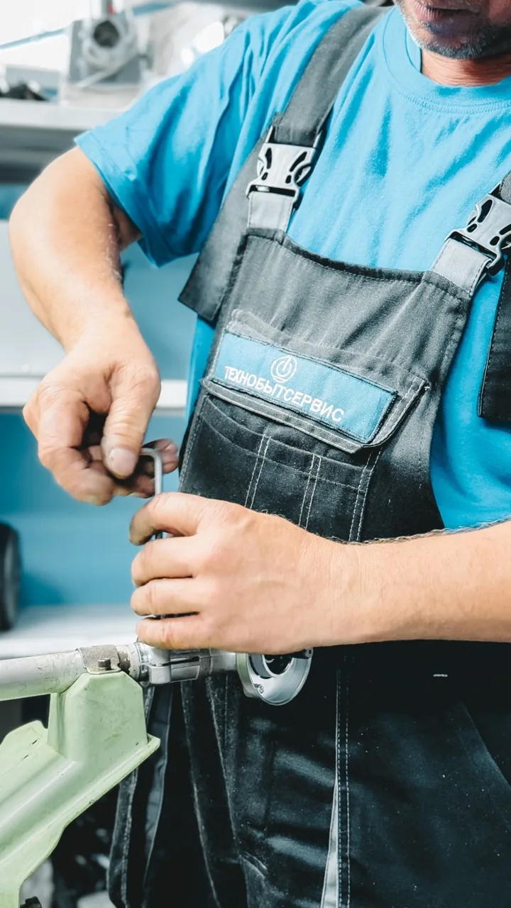 Mains manipulant une clé sur un raccord de tuyauterie — photo d’illustration