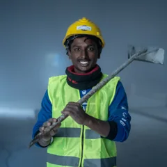 Homme souriant en casque et gilet de sécurité — photo d’illustration